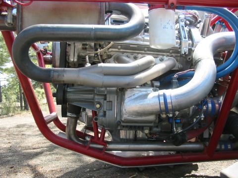 1993 Ford Taurus - Aluminum V6 engine mounted in a red tube-frame chassis outdoors, fitted with custom welded stainless exhaust headers, polished intake tubin…
