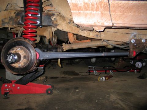 1995 Ford Bronco - Close-up view of a vehicle's modified suspension system, a red coilover and a gray control arm.