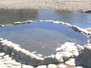1986 Ford Bronco - A natural hot spring is pictured next to a river, with a watermark indicating the source as Supermotors.