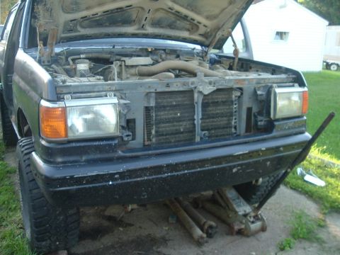 1989 Ford Bronco - The front of a 1989 Ford Bronco is shown with its hood open, revealing the engine compartment and radiator.