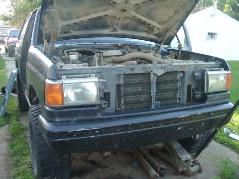 1989 Ford Bronco - Front view of a 1989 Ford Bronco with the hood open, revealing the engine compartment.