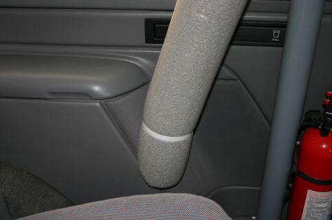 1994 Ford Bronco - A fire extinguisher is mounted inside the vehicle next to a padded roll bar.