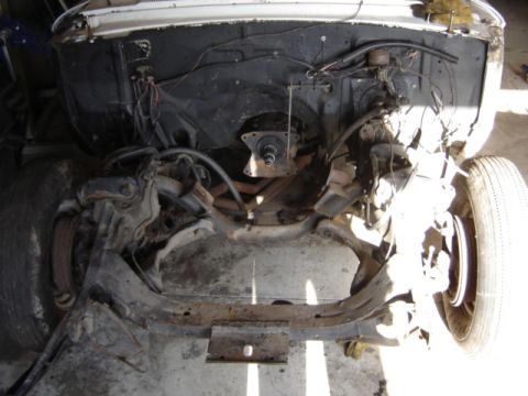 1963 Ford Galaxie - The engine bay and front suspension of a white 1963 Ford Galaxie are visible, indicating a restoration project.