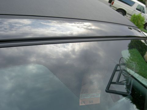 2005 Ford Mustang - The reflection on the windshield of this 2005 Ford Mustang shows a cloudy sky and a white van in the background.