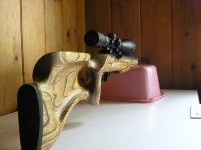 Rifle with wooden stock and scope on a table