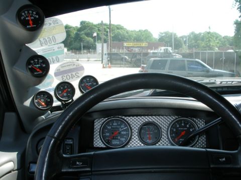 1994 Ford Bronco - Dashboard features multiple aftermarket gauges, including a voltmeter and transmission temperature gauge, visible through the windshield.