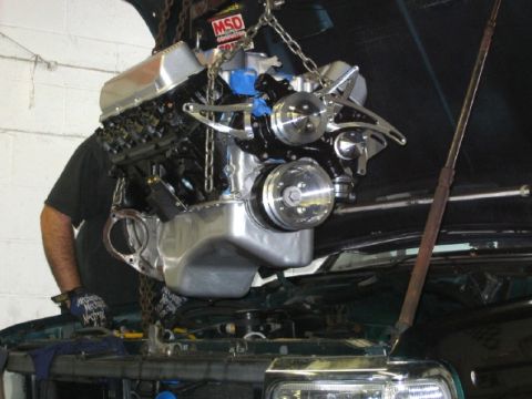 1994 Ford Bronco - Engine installation in progress, showing a V8 engine being lowered into place.