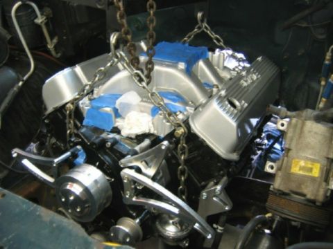 1994 Ford Bronco - Engine installation in progress, polished aluminum components and suspension chains.