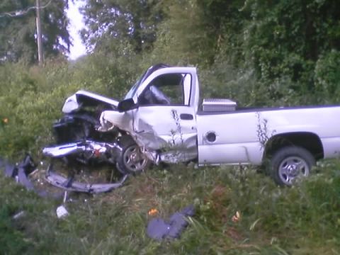 1985 Ford Bronco - A white pickup truck sustained heavy damage to its front end after an apparent collision.