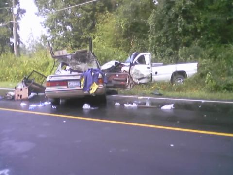 1985 Ford Bronco - Two vehicles were involved in a severe accident on a wet road, with debris scattered around.