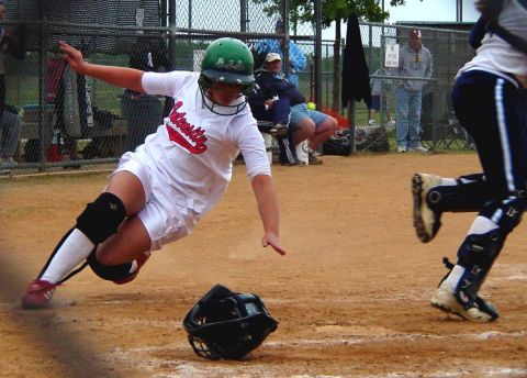 2000 Ford Taurus - A softball player slides into a base during a game, with a catcher in the foreground.