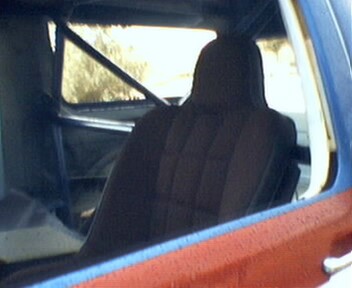 1981 Ford Bronco - Interior of a vehicle, likely a truck or SUV, with a roll cage installed. Supermotors.net logo is present.