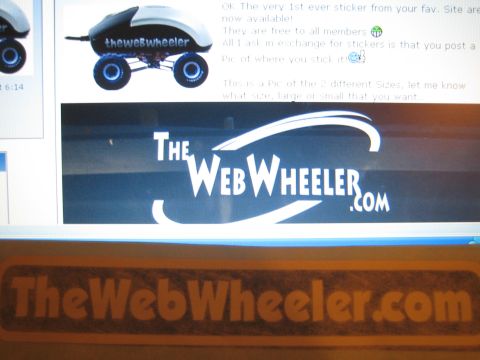 1990 Ford Bronco - orange TheWebWheeler.com decal rests in front of a monitor showing the site's logo and a sticker-offer post.