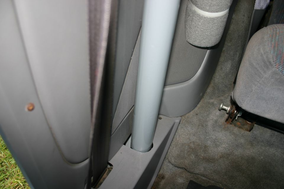 Gray SUV interior showing B-pillar, seat belt, grab rail and seat mount bolt