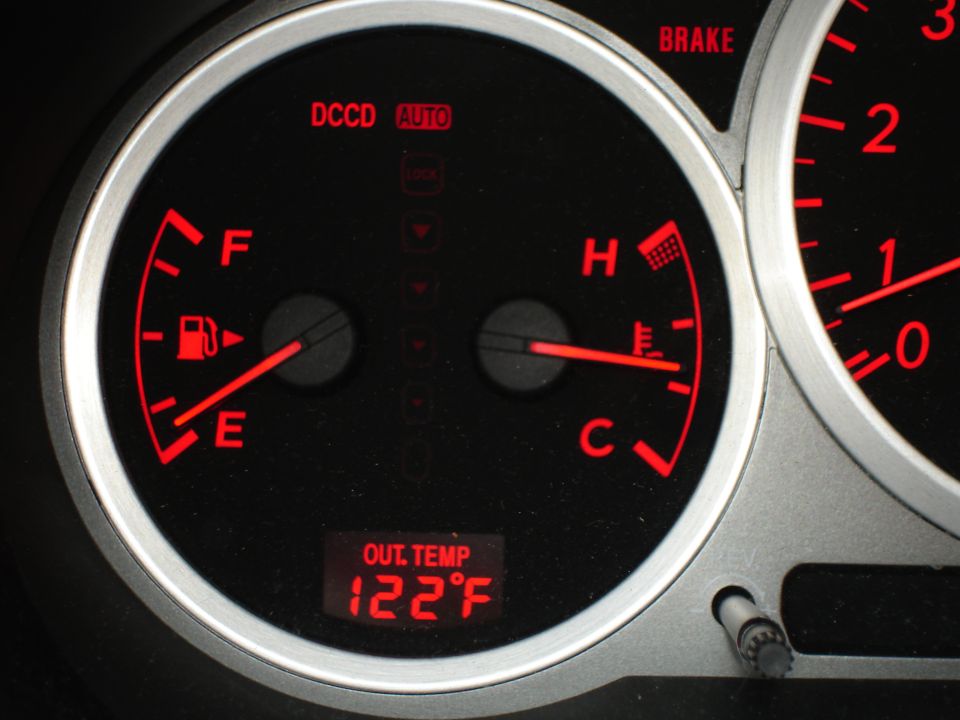 Red-lit dashboard cluster with fuel and temp gauges, DCCD AUTO and 122F outside temp