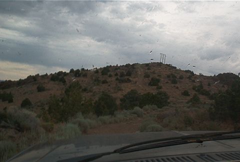 1986 Ford Bronco - View from inside a vehicle looking out at a desolate, hilly terrain under a cloudy sky.