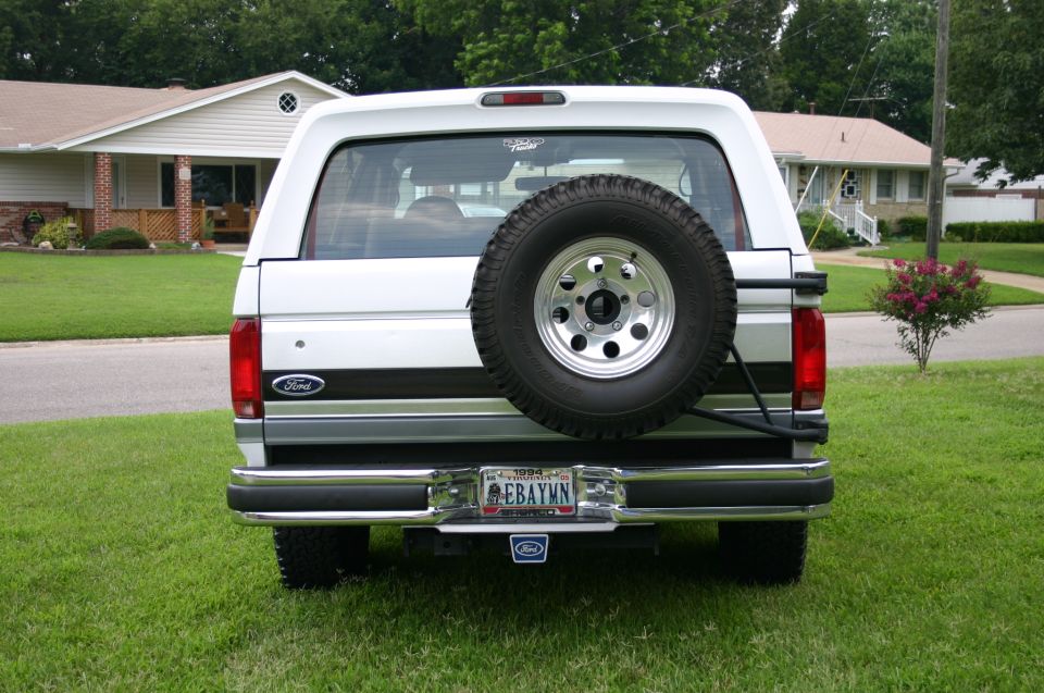 Rear of white and gray Ford Bronco with spare tire carrier and EBAYMN Virginia plate