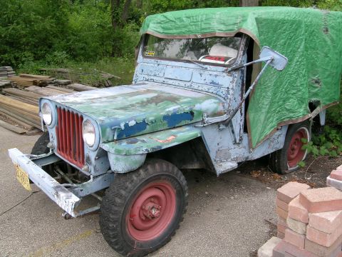 1950 Jeep CJ5 - This Jeep Willys CJ-3A has seen better days, with its weathered paint and a protective tarp over the rear section.