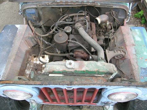 1950 Jeep CJ5 - Engine bay of a 1950 Jeep CJ5, showing the engine, radiator, and surrounding components.