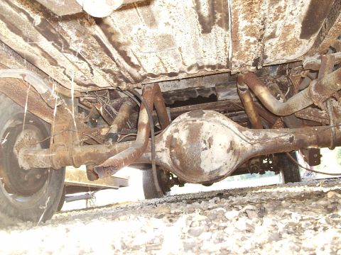 1979 Ford F-150 - The underside of a heavily rusted truck reveals its rear differential and exhaust system.