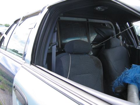 1991 Ford LTD Crown Victoria - Interior view of car seats and partition, showing the back of the front seats and the separation between the passenger and cargo areas.