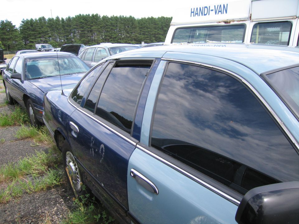 Side view of a two-tone blue sedan with tinted windows and chrome trim