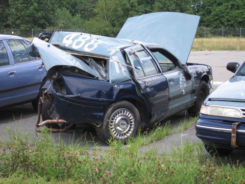 1991 Ford LTD Crown Victoria - This heavily damaged vehicle appears to be a former police car, with visible markings and the number 488 on its roof.