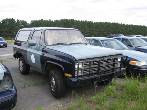 1991 Ford LTD Crown Victoria - This two-tone SUV features a prominent brush guard and is parked in a lot with other vehicles.