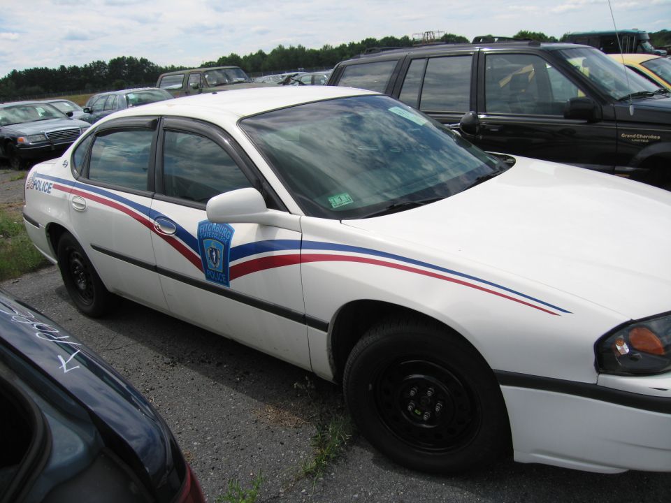 White police car with red and blue stripes on its side
