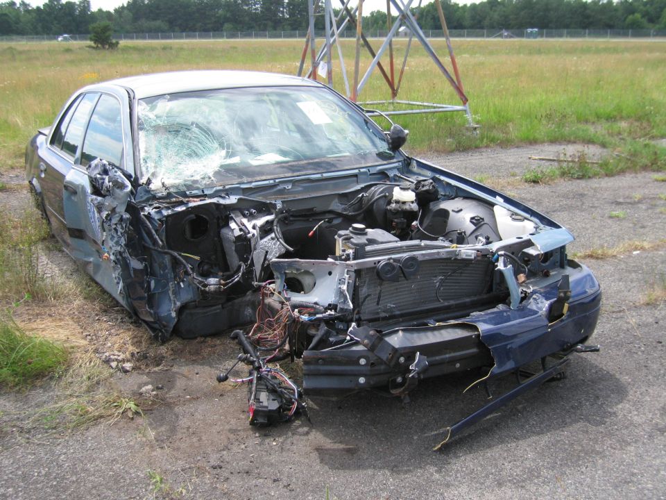 1991 Ford Crown Victoria LTD with severe front-end damage, windshield cracked, engine exposed