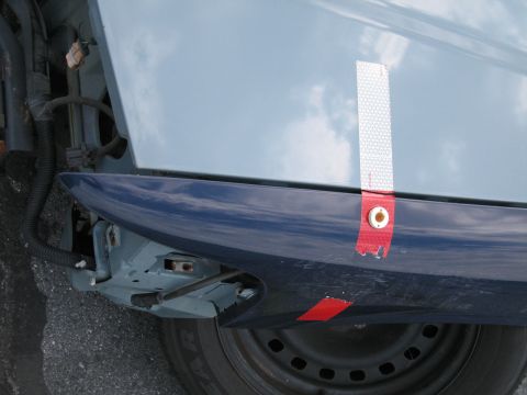 1991 Ford LTD Crown Victoria - Close-up of a car's front fender, revealing damage and exposed mechanical components.
