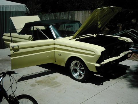 1978 Ford Bronco - A vintage Ford Falcon convertible with its doors and hood open, parked outdoors at night.