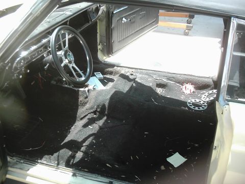 1978 Ford Bronco - The interior of a car is shown with the carpet removed, revealing the floor and wiring.