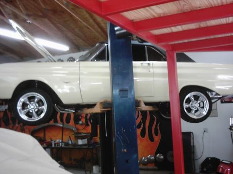 1978 Ford Bronco - 1964 Ford Falcon coupe on a lift with its hood open, showing custom wheels.