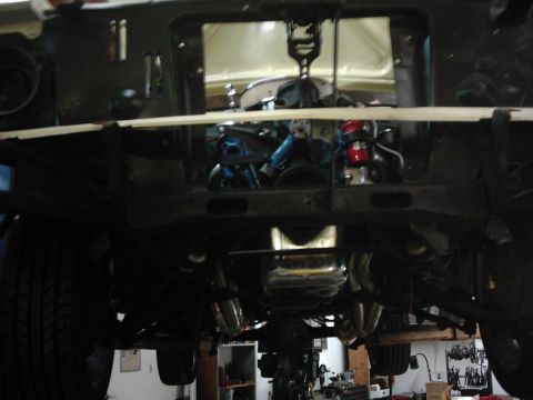 1978 Ford Bronco - The engine and undercarriage of a vehicle are shown, likely in a workshop setting.