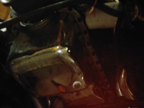 1978 Ford Bronco - Close-up view of a vehicle's oil pan, showing its metallic surface and bolt pattern.