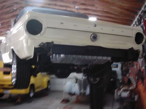 1978 Ford Bronco - Rear view of a 1964 Ford Falcon convertible undergoing work in a garage.