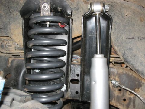 1995 Ford Bronco - The photo shows the front suspension system, including a coil spring and shock absorber, of a vehicle.
