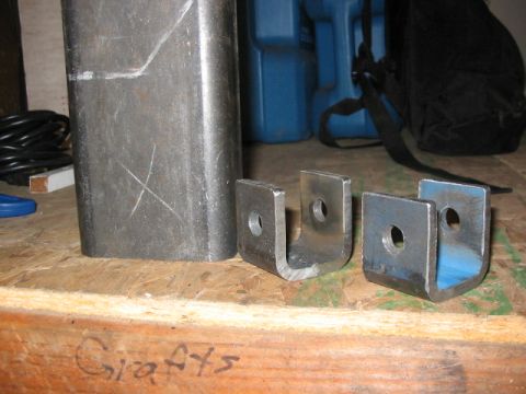 1995 Ford Bronco - Metal parts are laid out on a workbench, with tools and storage containers visible in the background.