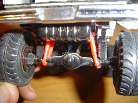 1979 Ford Bronco - Close-up view of the rear axle and suspension system on a model truck, showing orange shock absorbers.