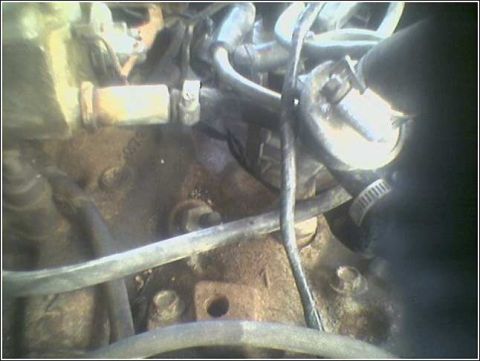 1981 Ford Bronco - Close-up view of engine bay components, including hoses and metal parts.