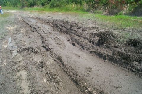 1988 Ford Bronco - A vehicle has clearly struggled to navigate this extremely muddy and rutted off-road path.