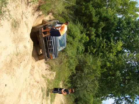 1990 Ford Bronco - Ford Bronco stuck in a dirt ditch, with a person on the running board and another watching.