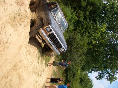 1990 Ford Bronco - This 1979 Ford F-Series truck is shown in a three-quarter front view, navigating a sandy terrain.