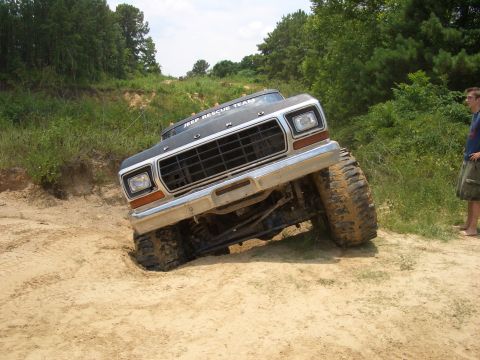 1990 Ford Bronco - Ford F-Series truck with "JEEP RESCUE TEAM" text on roof, stuck in sand during off-road activity.