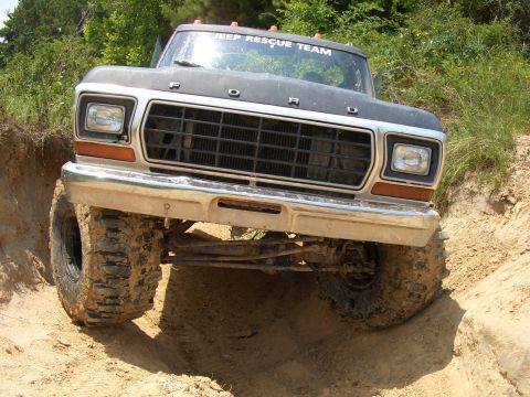 1990 Ford Bronco - This Ford truck is navigating a steep dirt path with its front wheels turned.