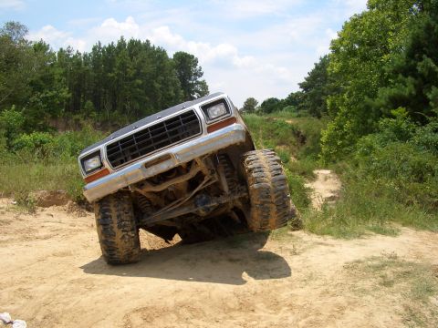 1990 Ford Bronco - This lifted Ford Bronco navigates a challenging dirt path, its off-road capabilities.