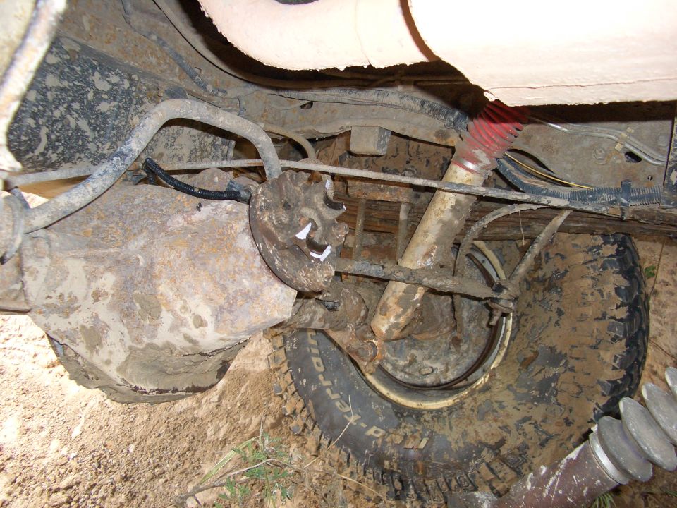 Rear axle and suspension of a muddy vehicle with a red shock absorber