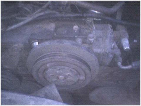 1981 Ford Bronco - Close-up of an engine component, likely an air conditioning compressor.