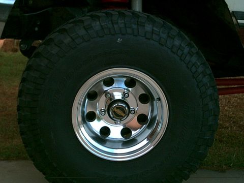 1988 Ford Bronco - Close-up of a polished alloy wheel and off-road tire on a vehicle.